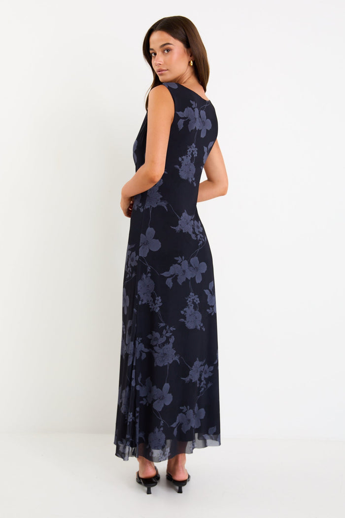 Model wearing a sleeveless midnight floral mesh maxi dress with gentle gathering at the waist and a slim, draped silhouette.