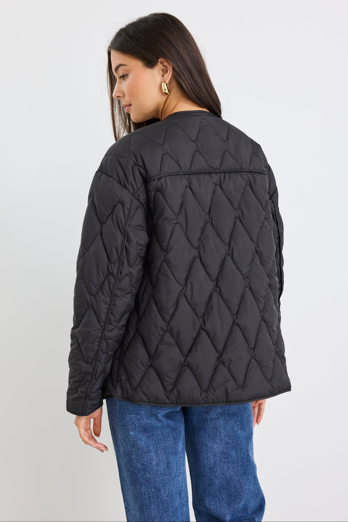 Person wearing a black quilted jacket on a white background
col_pattern