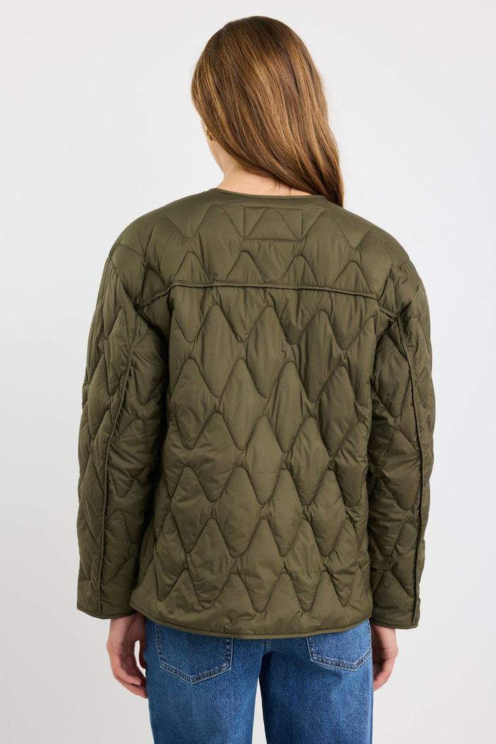 Person wearing a green quilted jacket on a white background
col_pattern