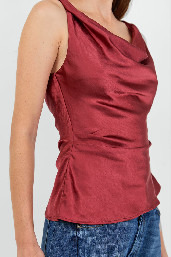 Close up of side draping on a red cowl neck top.