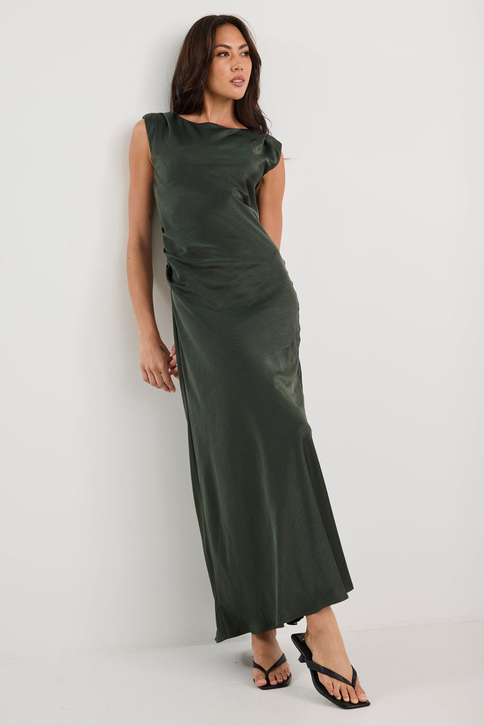 Woman wearing a long green dress against a white background