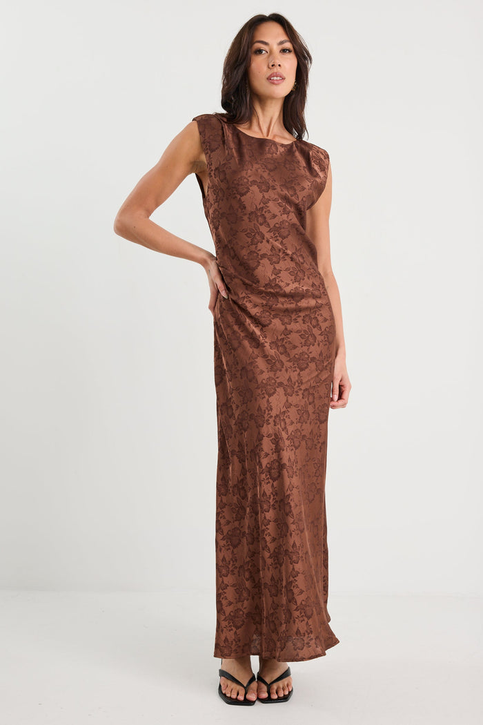 Woman wearing a brown patterned dress on a white background