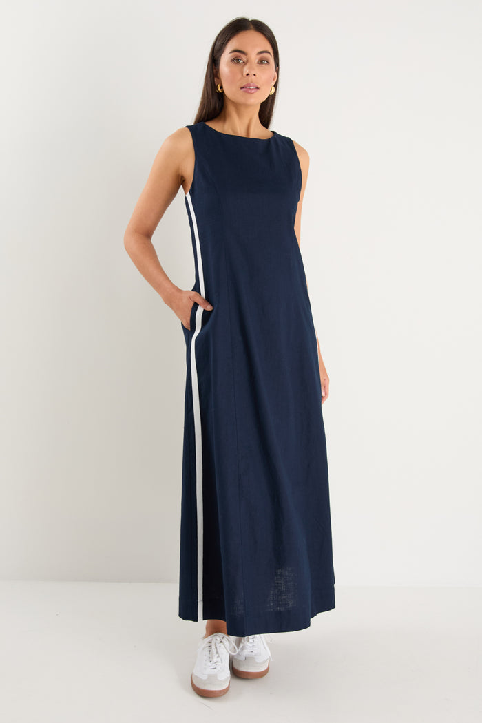 the model wears a navy and white stripe maxi dress with sneakers
