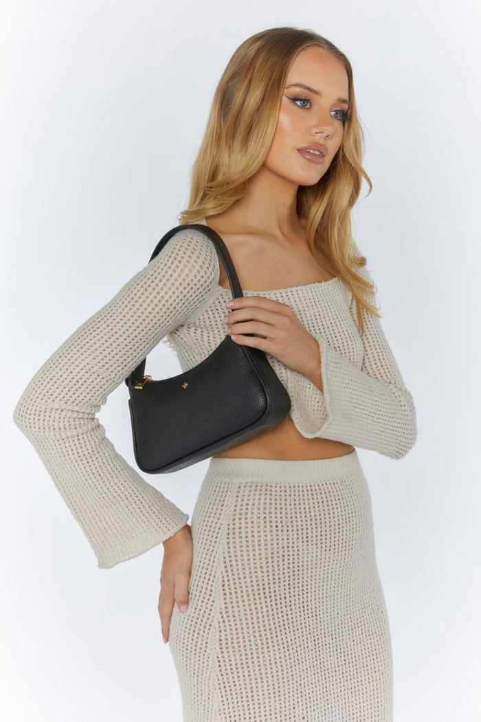 model with black leather handbag
