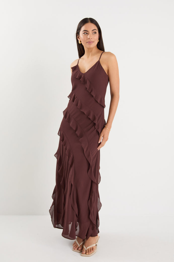 Woman wearing a brown ruffled dress on a white background