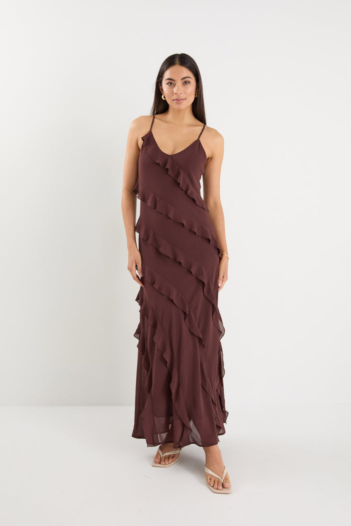 Woman wearing a brown ruffled dress on a white background
