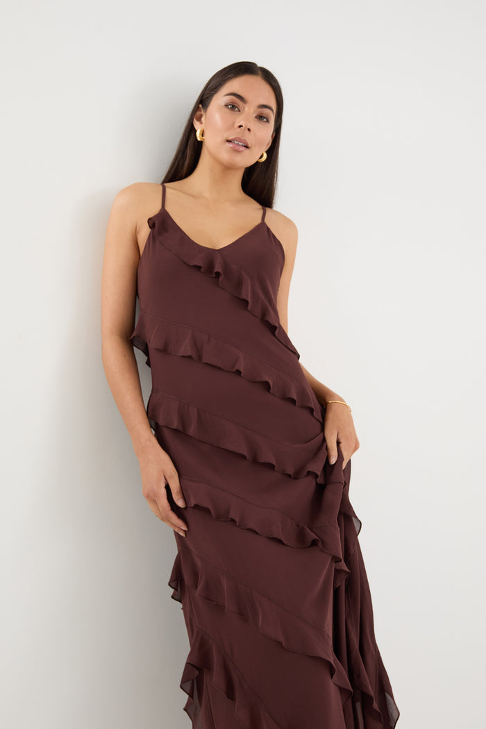 Woman wearing a brown ruffled dress against a white background