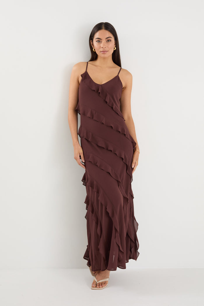 Woman wearing a brown ruffled dress against a white background