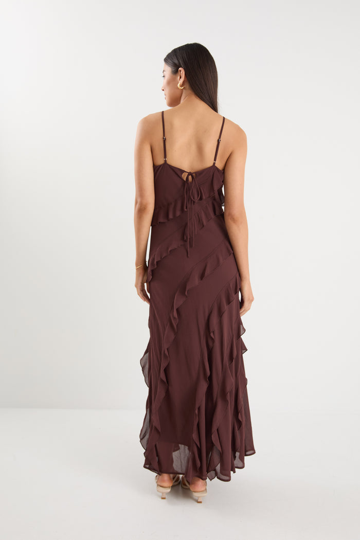 Woman wearing a brown ruffled dress on a white background