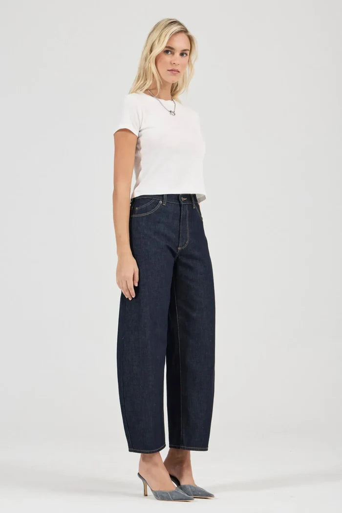 Woman wearing dark blue jeans and a white top on a white background