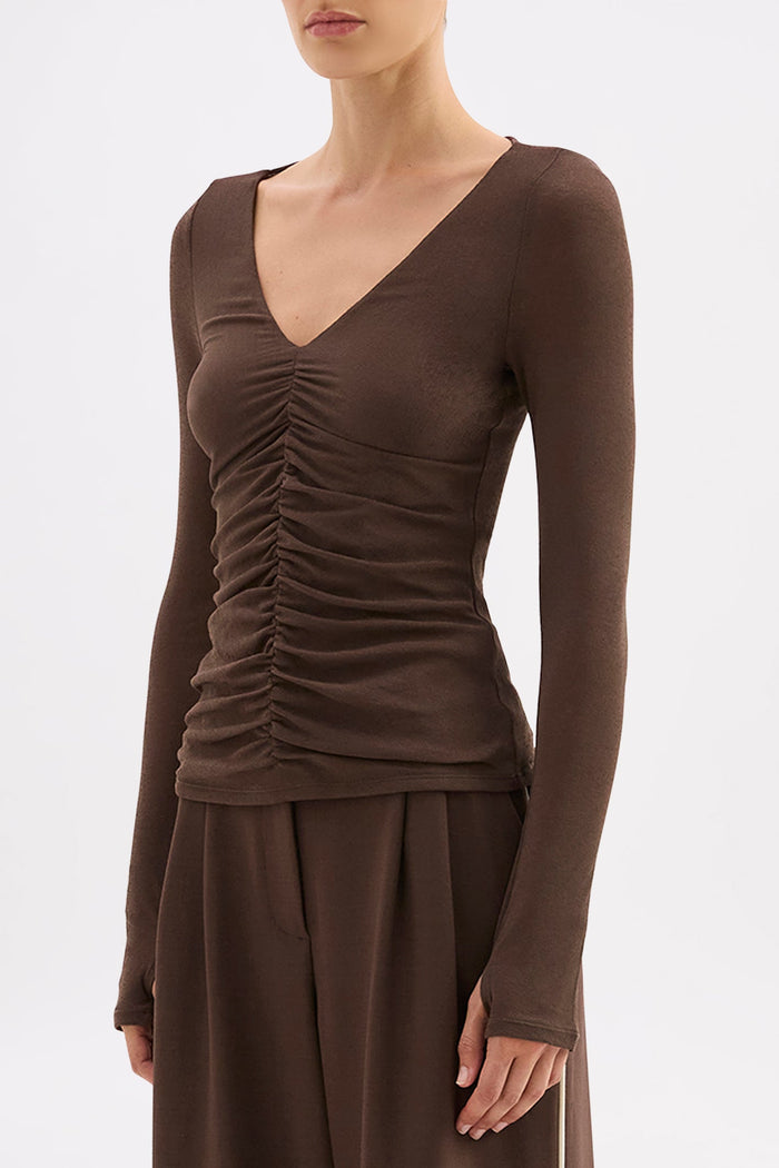 Brown long-sleeve top with ruched design and matching pants on a white background