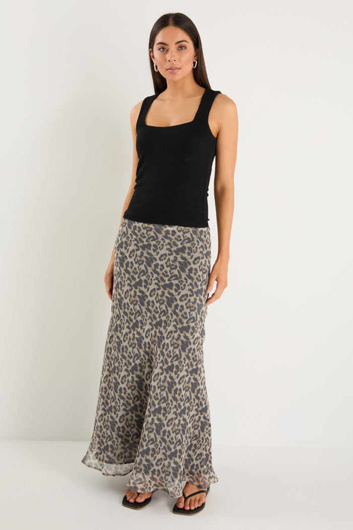 model wears a leopard maxi skirt with a black tank top