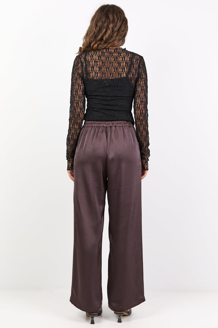 Person wearing a black lace top and brown pants on a white background
col_pattern