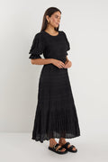 model wears a black maxi dress with black sandals