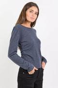 Woman wearing a blue sweater and black pants on a white background