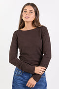 Woman wearing a brown long-sleeve top and blue jeans on a white background