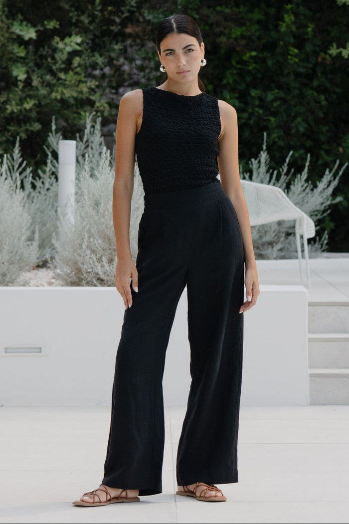 Woman wearing a black pant and black tank