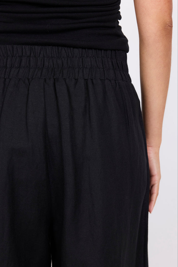 Black pants worn by a person on a white background