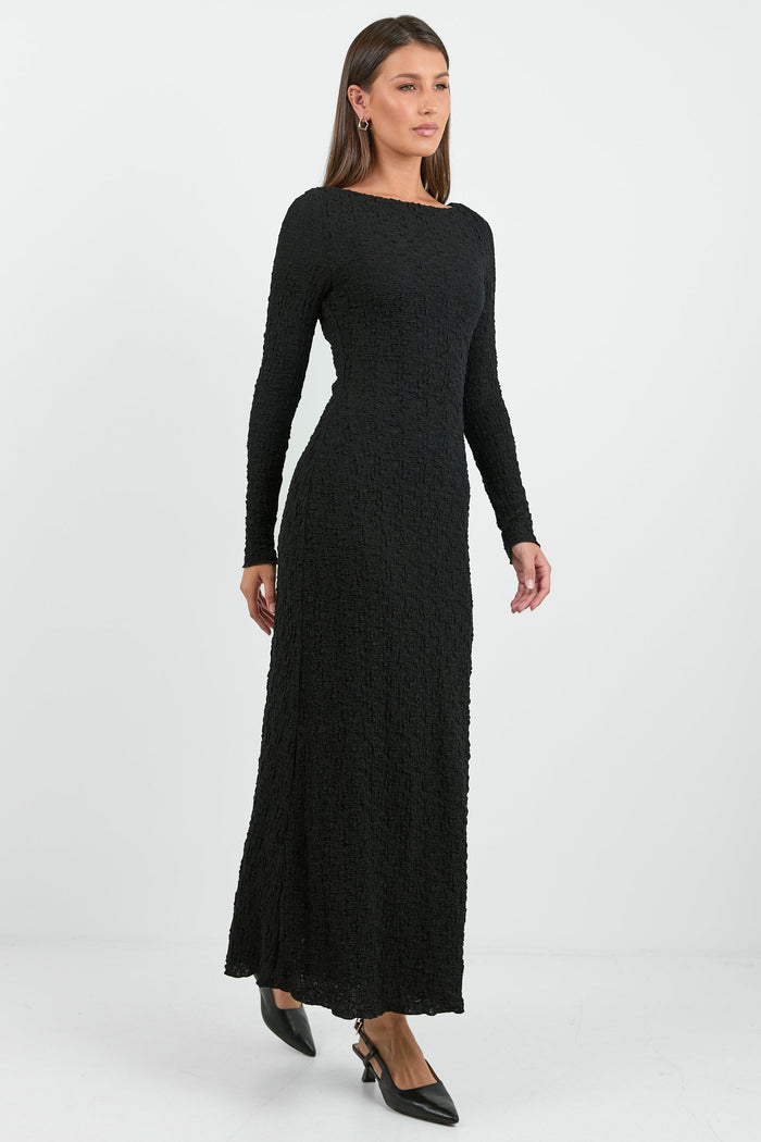 Woman wearing a black long-sleeve dress on a white background