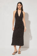 Woman wearing a black dress with white polka dots on a white background