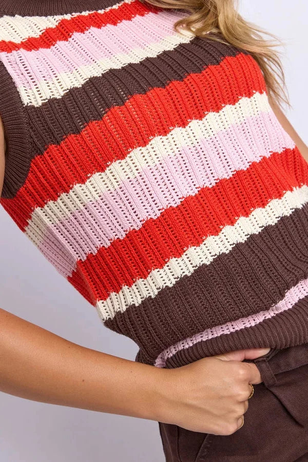 A close-up of a sleeveless ribbed knit top with horizontal stripes in brown, red, cream, and light pink, worn by a model.