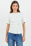 Woman wearing a white t-shirt with a twist and clasp detail and blue jeans on a white background