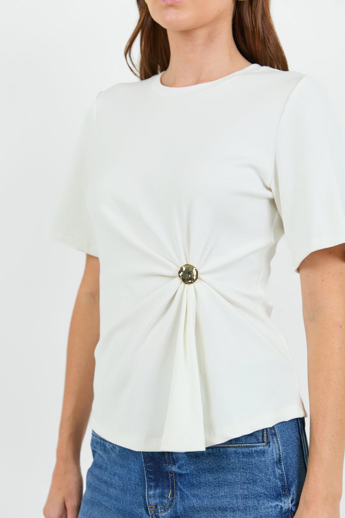 Close up of a woman wearing a white t-shirt with a twist and clasp detail and blue jeans on a white background