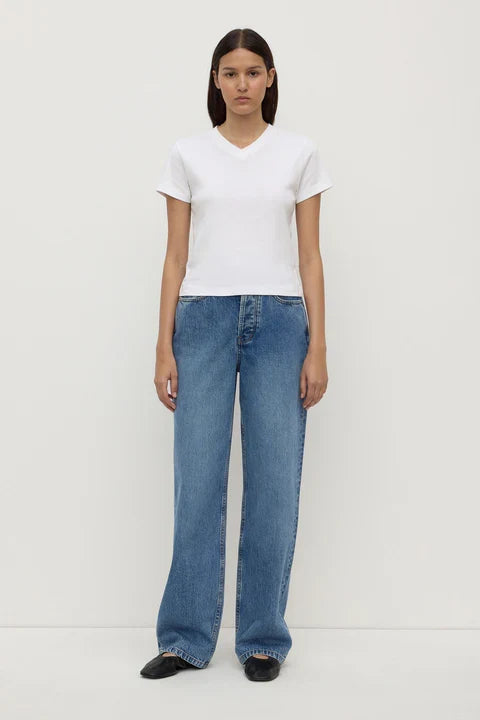Person wearing a white t-shirt and blue jeans on a white background