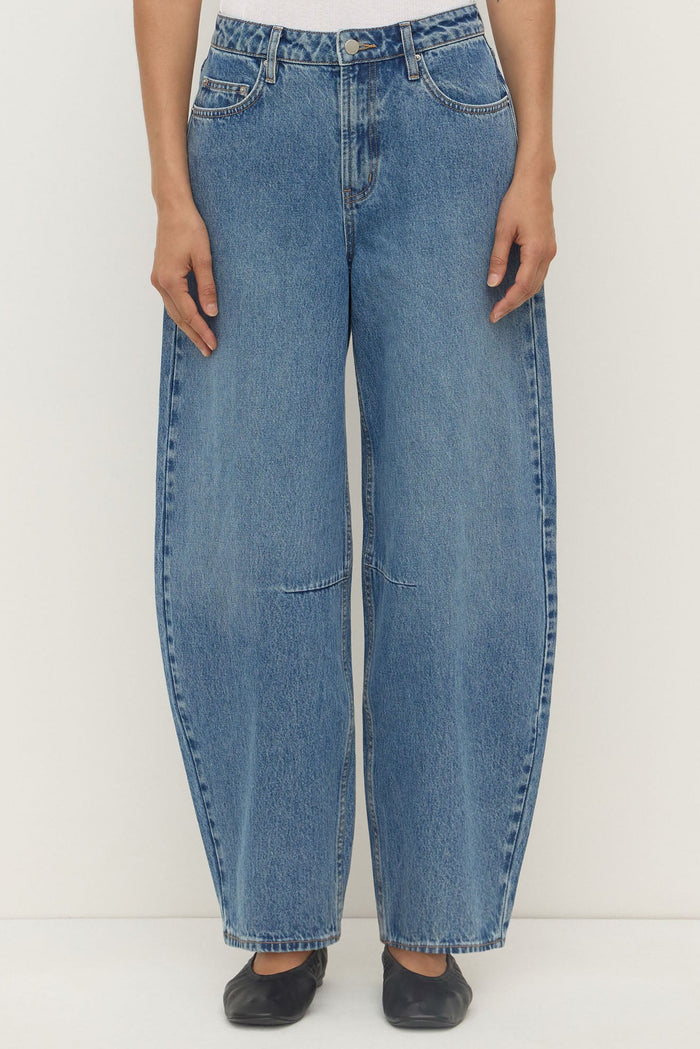 Blue jeans worn by a person on a white background