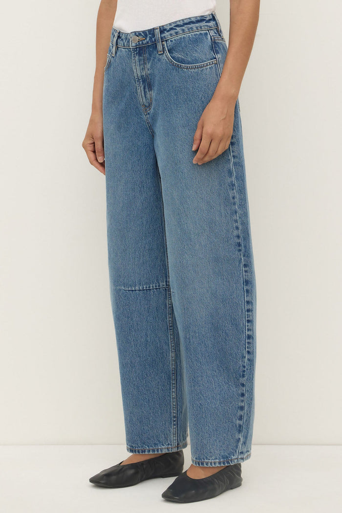 Person wearing blue jeans on a white background