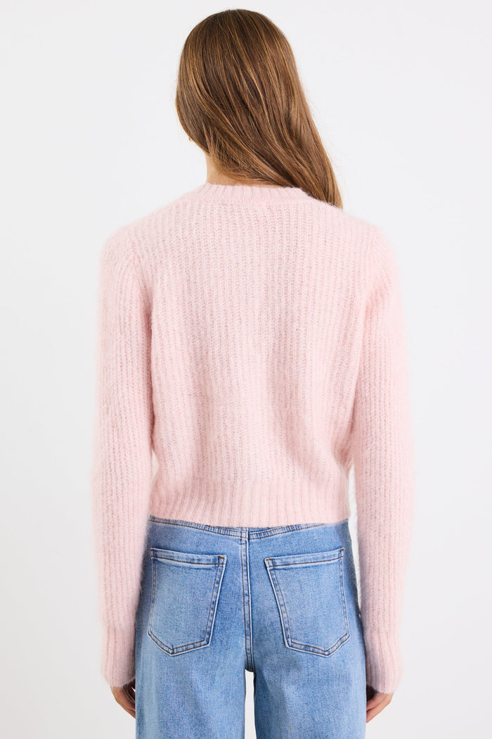 Person wearing a light pink sweater and blue jeans on a white background
col_pattern