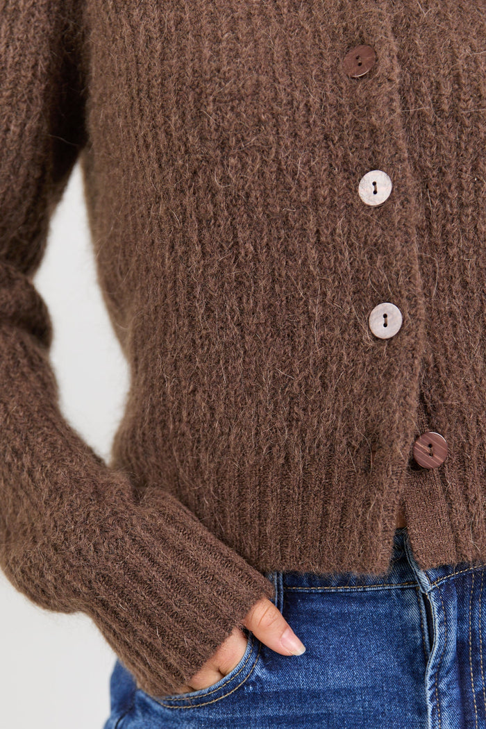 Brown knitted cardigan worn by a person with a white background