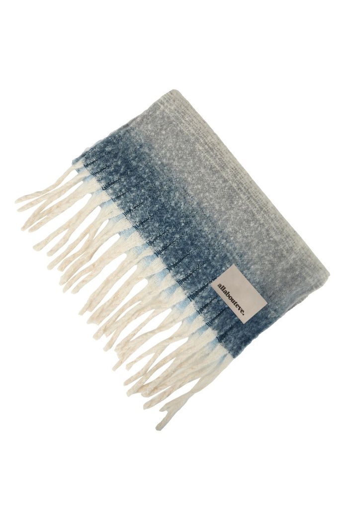 Gray and blue plaid blanket with white fringes on a white background