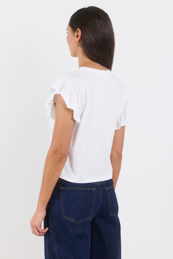 Person wearing a white top and dark blue jeans on a white background