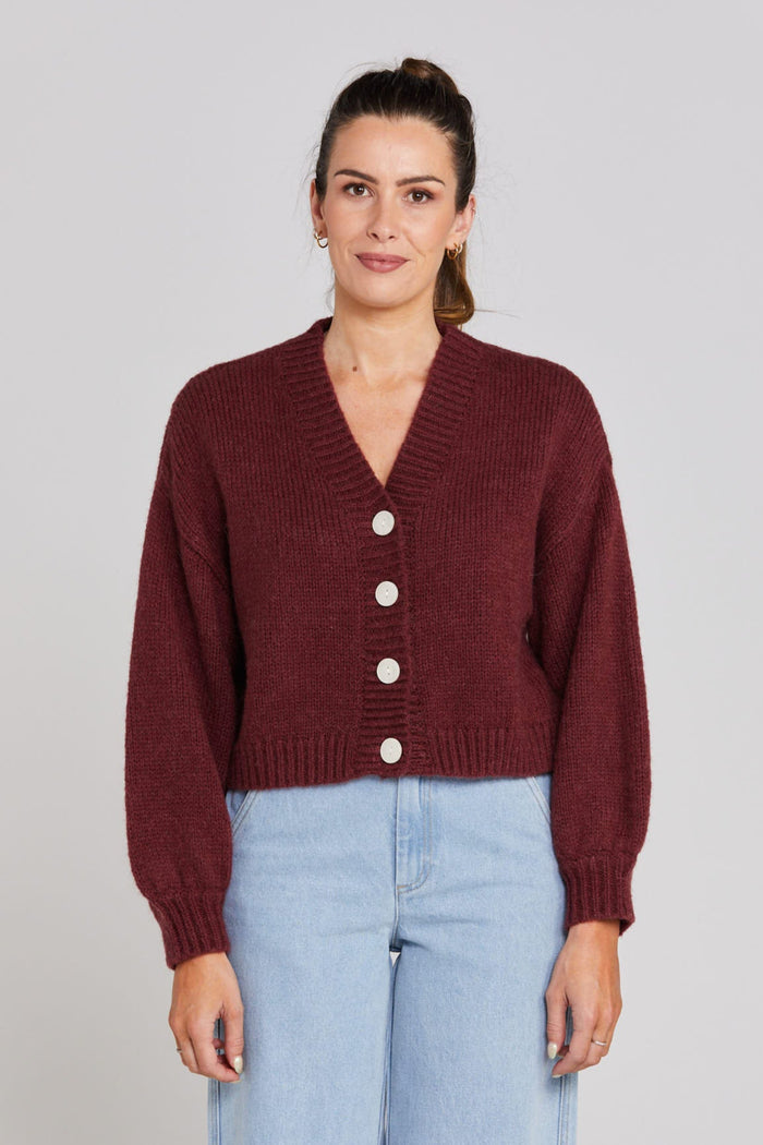 Model wears a burgundy long sleeve knit cardigan