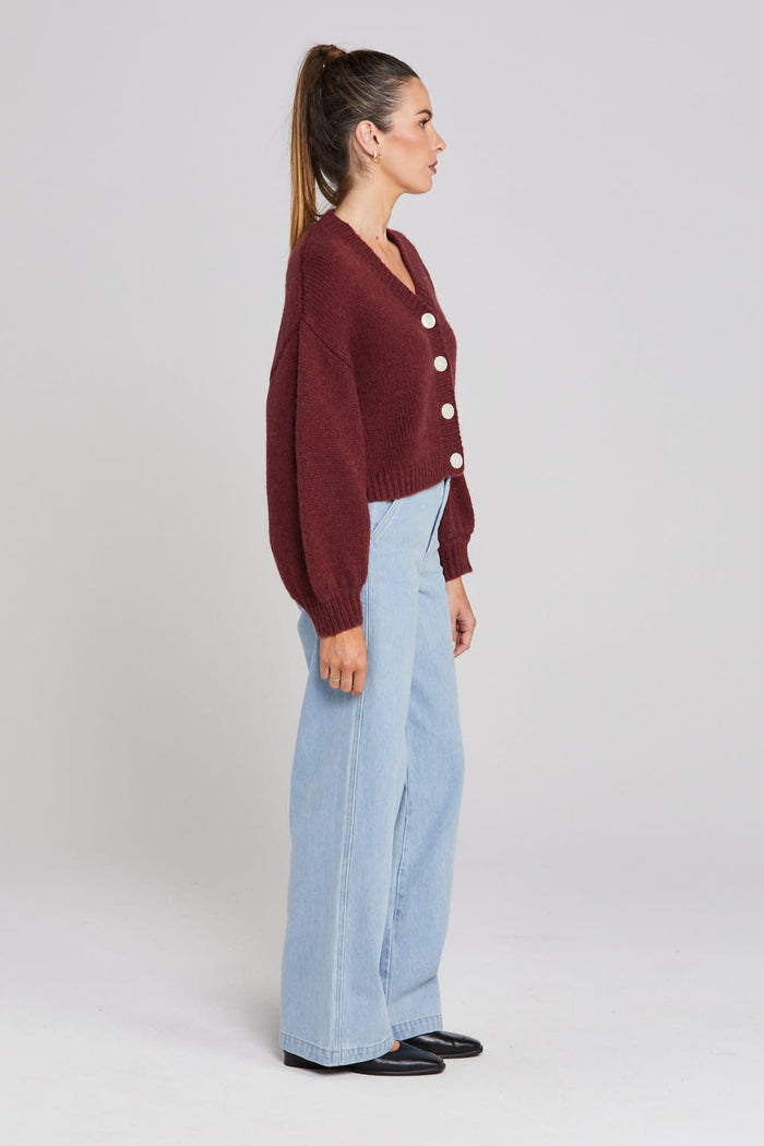 Model wears a burgundy long sleeve knit cardigan