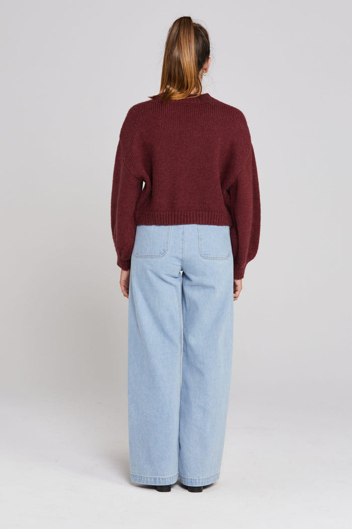 Model wears a burgundy long sleeve knit cardigan