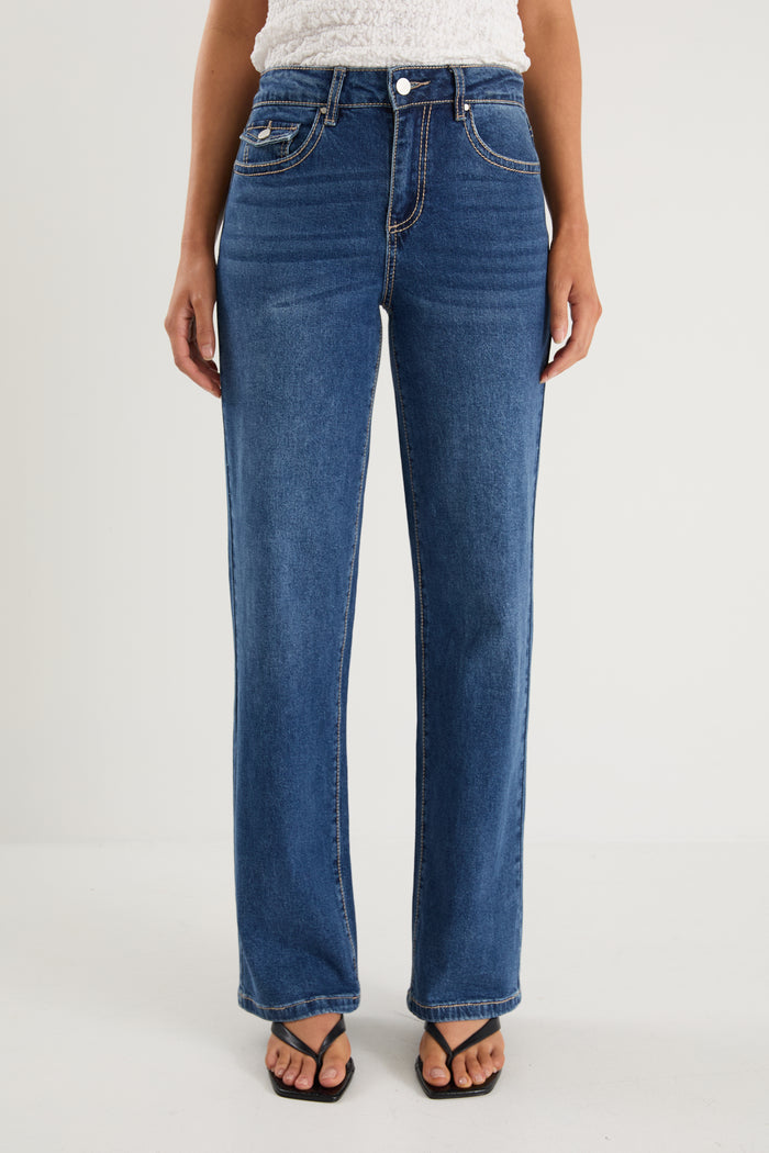 model wears a pair of blue jeans with a white tank top