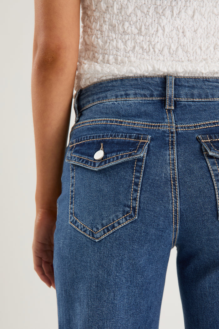 model wears a pair of blue jeans with a white tank top