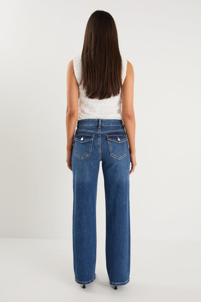 model wears a pair of blue jeans with a white tank top