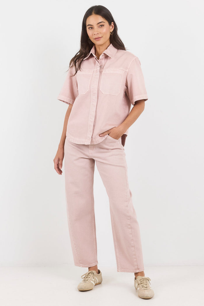 Woman wearing a pink outfit with a shirt and pants on a white background