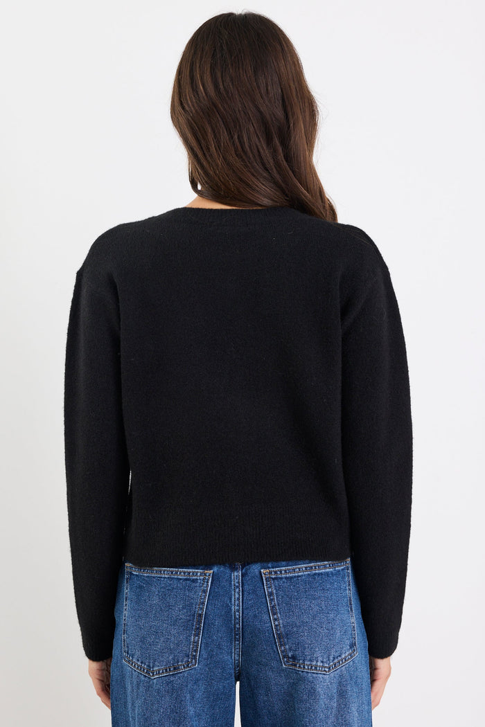 Person wearing a black sweater and blue jeans on a white background
col_pattern