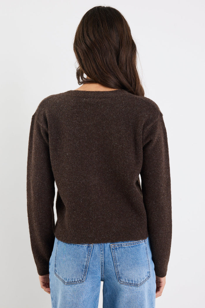 Person wearing a brown sweater and blue jeans against a white background
col_pattern