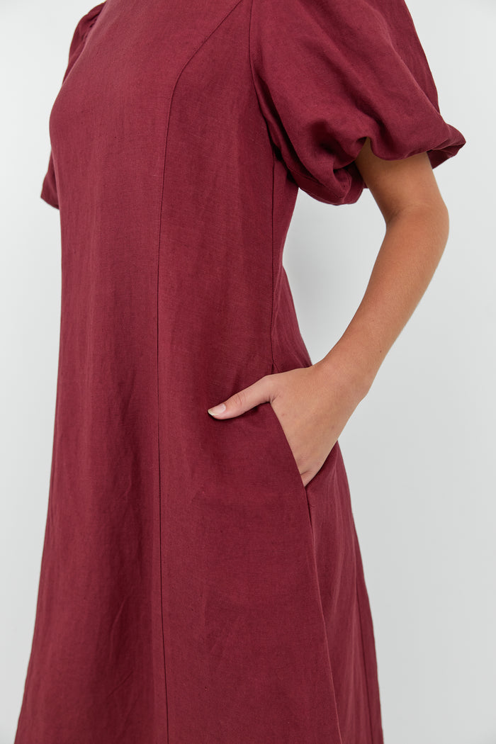Maroon dress with puff sleeves on a white background