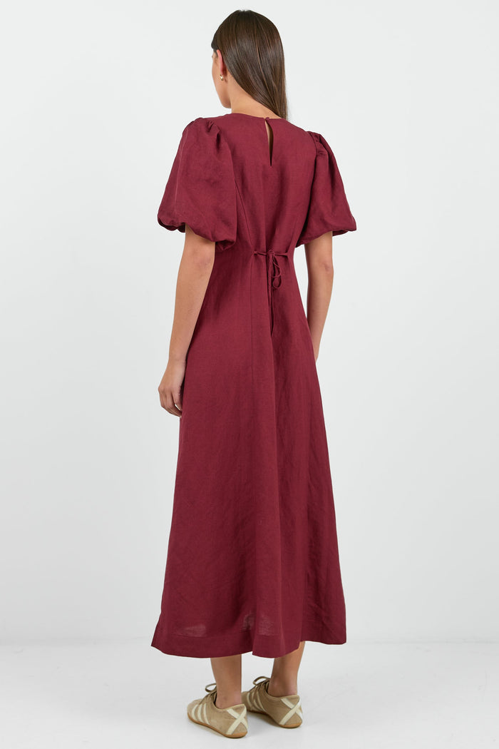 Woman wearing a burgundy dress on a white background