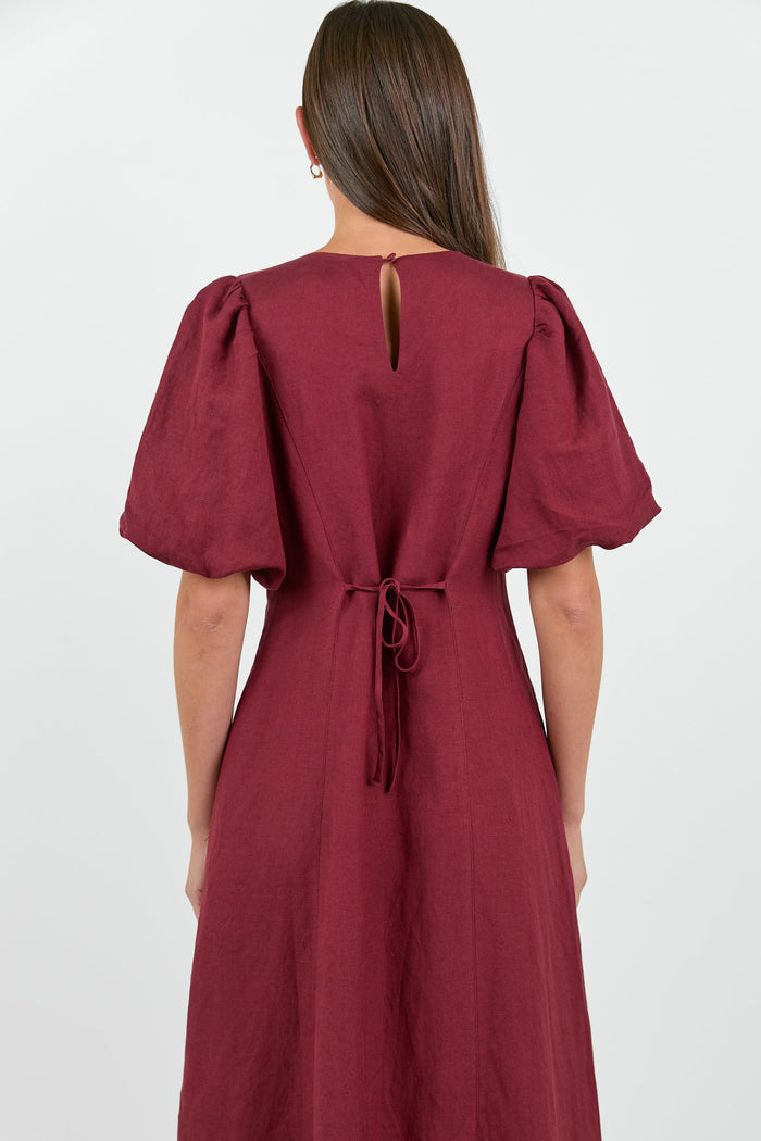 Maroon dress with puff sleeves on a white background
