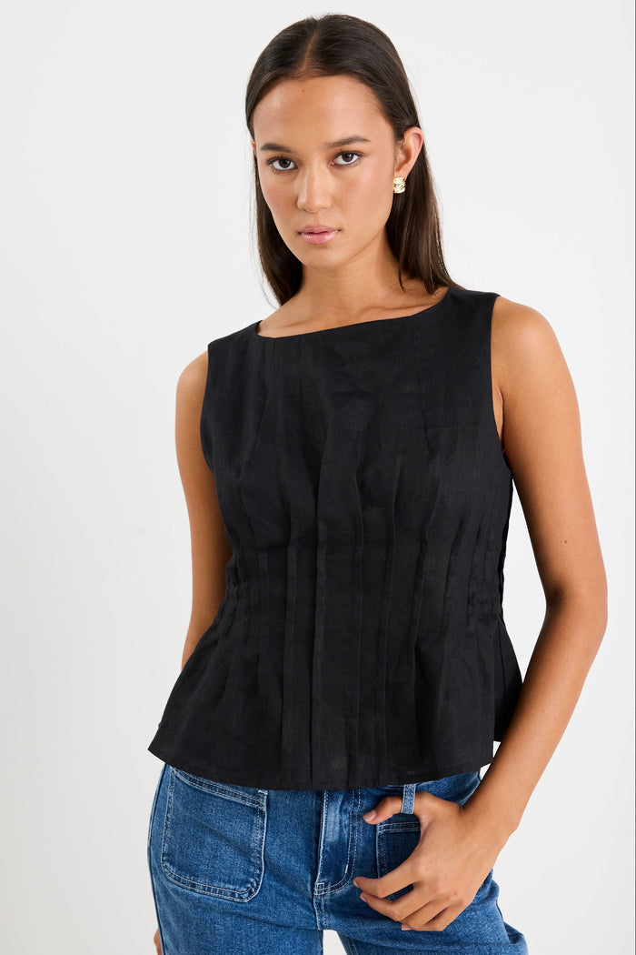 Woman wearing a black pintuck top with blue jeans