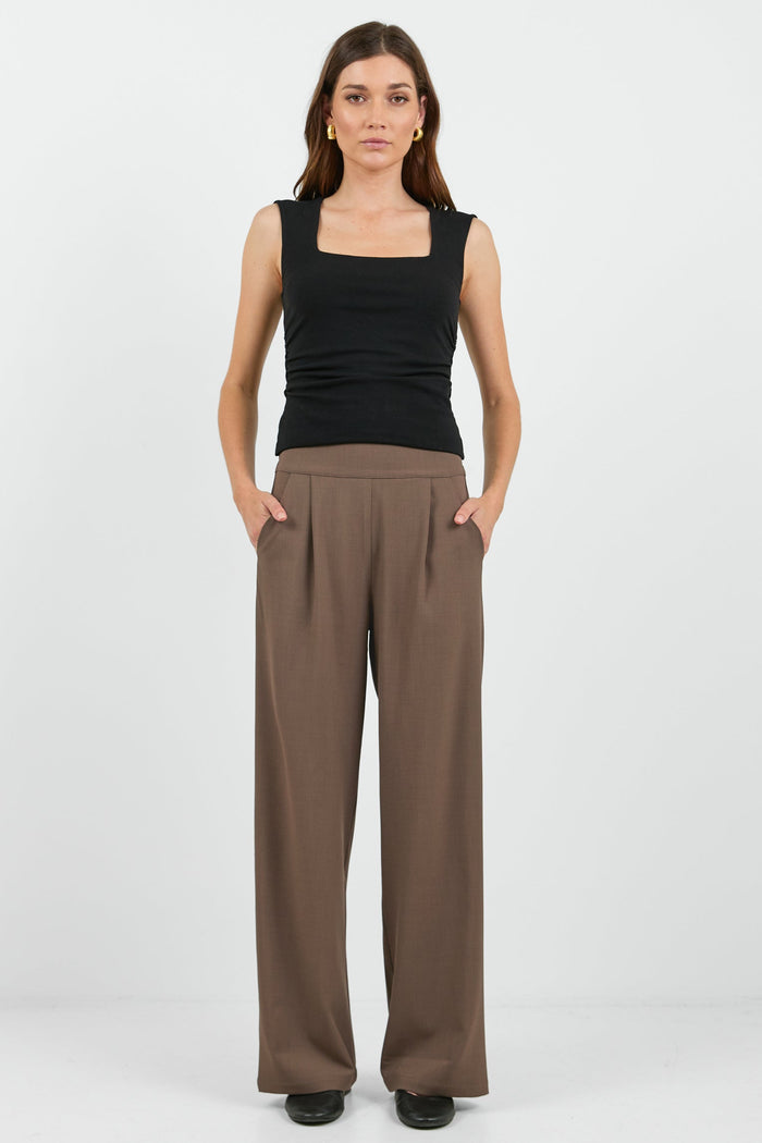 Women wearing black tank and brown pants.