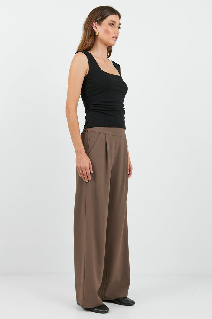 Women wearing black tank and brown pants.