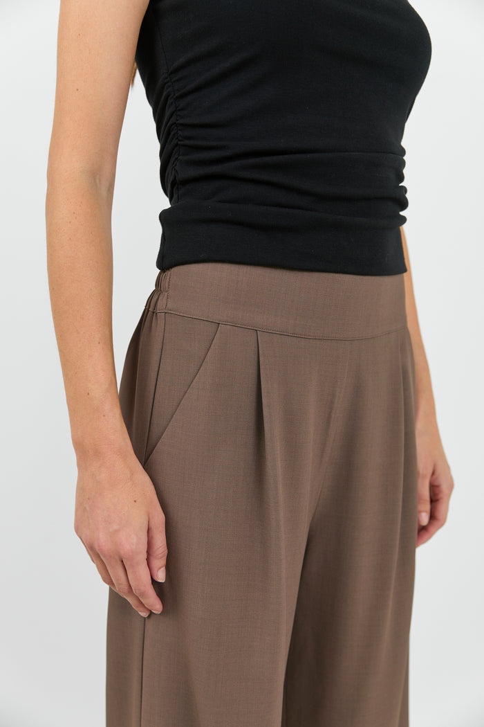 Women wearing black tank and brown pants.